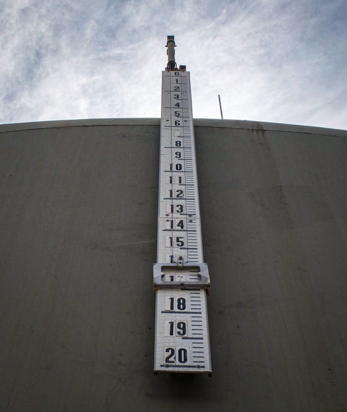 Low angle view of a large vertical thermometer on a building exterior.